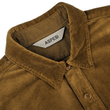 Close-up of the Tobacco Brown Cotton Velvet Overshirt by Aspesi, featuring a collar, buttons, and a label displaying the brand name "Aspesi." This casual alternative blazer crafted from pure cotton velvet exudes effortless style.