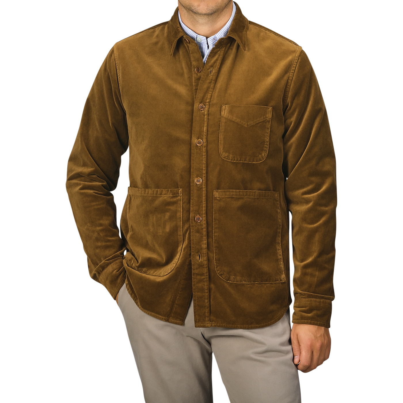 A person wearing the Aspesi Tobacco Brown Cotton Velvet Overshirt, featuring three front pockets and a collared design, stands with hands in pockets against a plain background. This ensemble, expertly crafted from pure cotton velvet, showcases the refined touch of an Italian outerwear specialist.