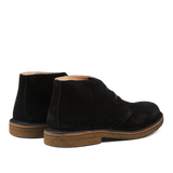 Sentence with product name and brand name: A pair of Astorflex Black Suede Greenflex Desert Boots with rubber soles, displayed on a plain background.