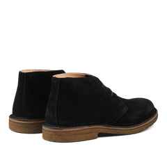 Sentence with product name and brand name: A pair of Astorflex Black Suede Greenflex Desert Boots with rubber soles, displayed on a plain background.