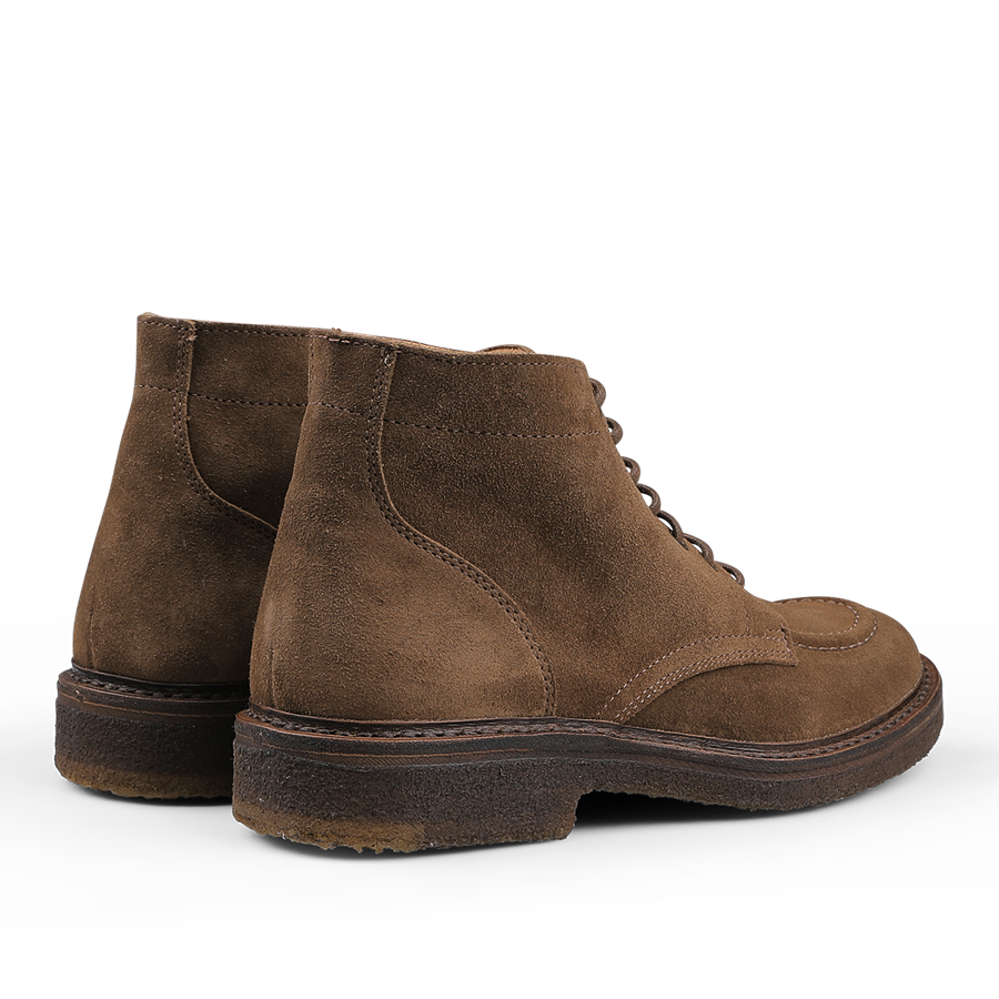 A pair of Dark Khaki Suede Leather Nuvoflex Boots by Astorflex, featuring laces and thick natural crepe rubber soles, viewed from the back.