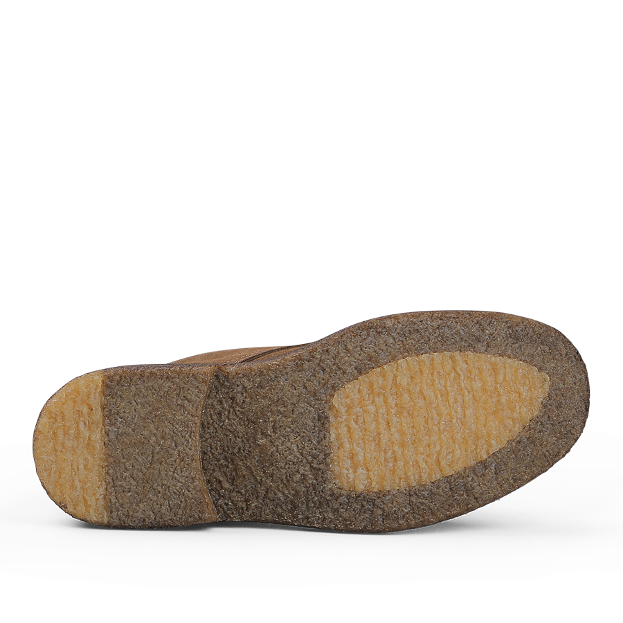 The image shows the sole of a Dark Khaki Suede Leather Nuvoflex Boot by Astorflex, crafted from natural crepe rubber and marked by a textured, tan-colored surface with visible heel and ball sections.