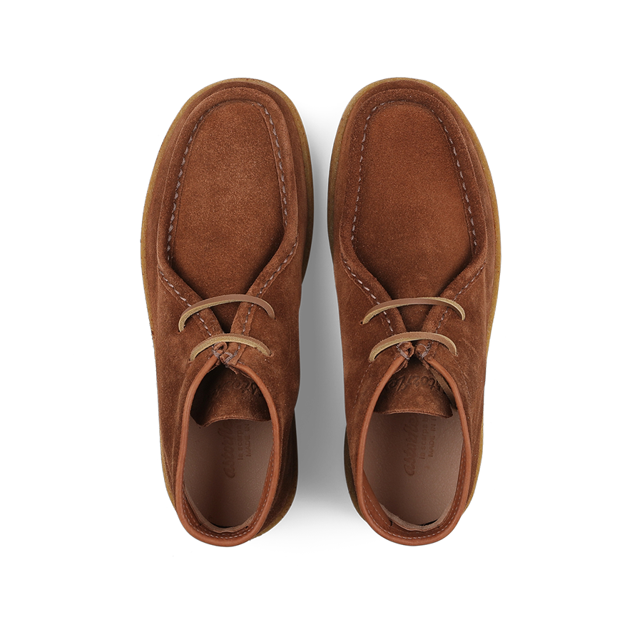 Astorflex's Mattone Brown Suede Rampiflex Boots are crafted from vegetable-tanned suede and feature two eyelets paired with beige laces, along with a natural crepe rubber sole for enhanced comfort and style.