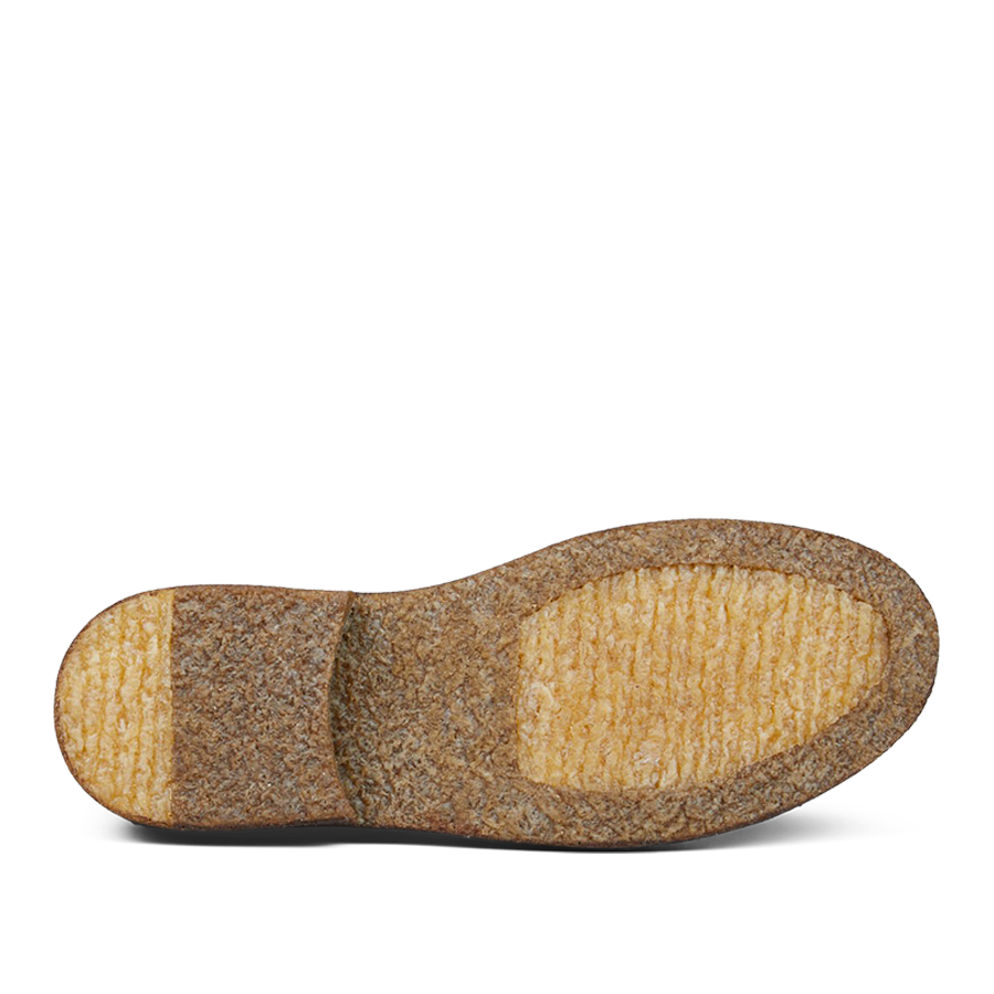 A worn-out Astorflex Testa di Moro Suede Greenflex desert boot sole with visible signs of heavy use, showing patches where the tread is completely worn away.
