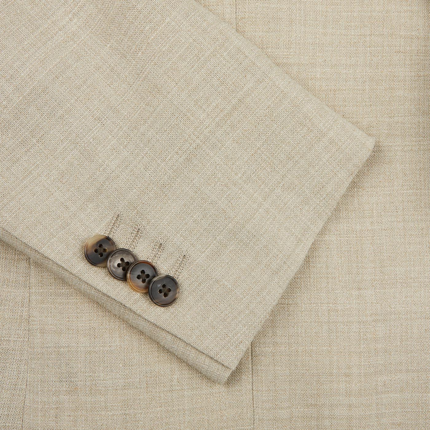 A close up of a button on a Baltzar Sartorial Beige Melange Wool Linen Suit Jacket.