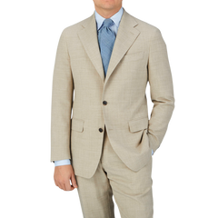 A man wearing a Baltzar Sartorial Beige Melange Wool Linen Suit Jacket and blue tie.