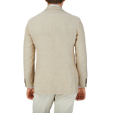 The back view of a man wearing a Baltzar Sartorial Beige Melange Wool Silk Linen Blazer.