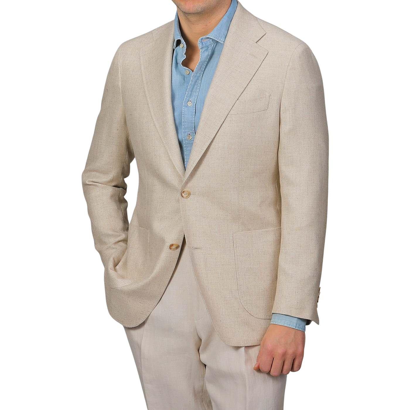 A man wearing a Baltzar Sartorial Beige Wool Silk Summer Tweed Blazer with a blue dress shirt poses with one hand in his pocket against a plain gray background.