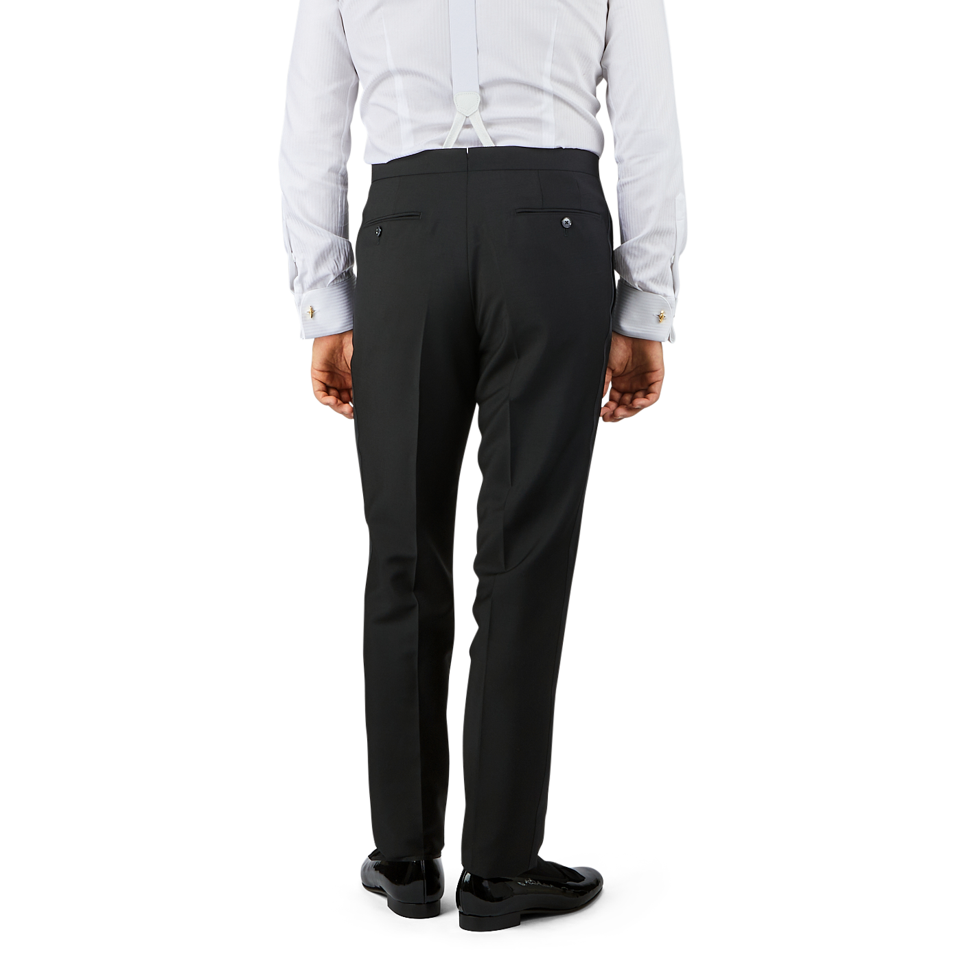 A person dressed in Baltzar Sartorial Black Wool Mohair Tuxedo Flat Front Trousers, a white shirt, and suspenders is shown from the back.