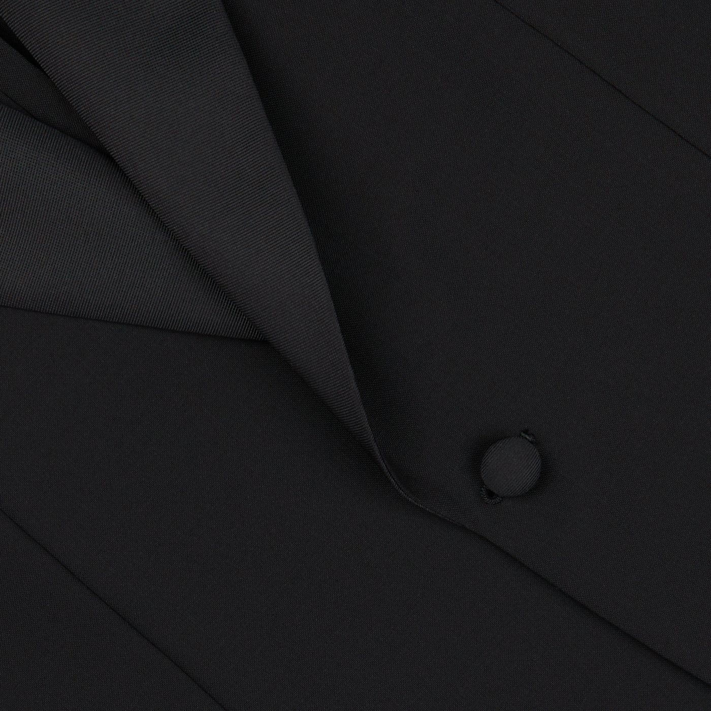 Close-up view of a Baltzar Sartorial Black Wool Mohair Tuxedo Jacket showing the lapel and a single button.