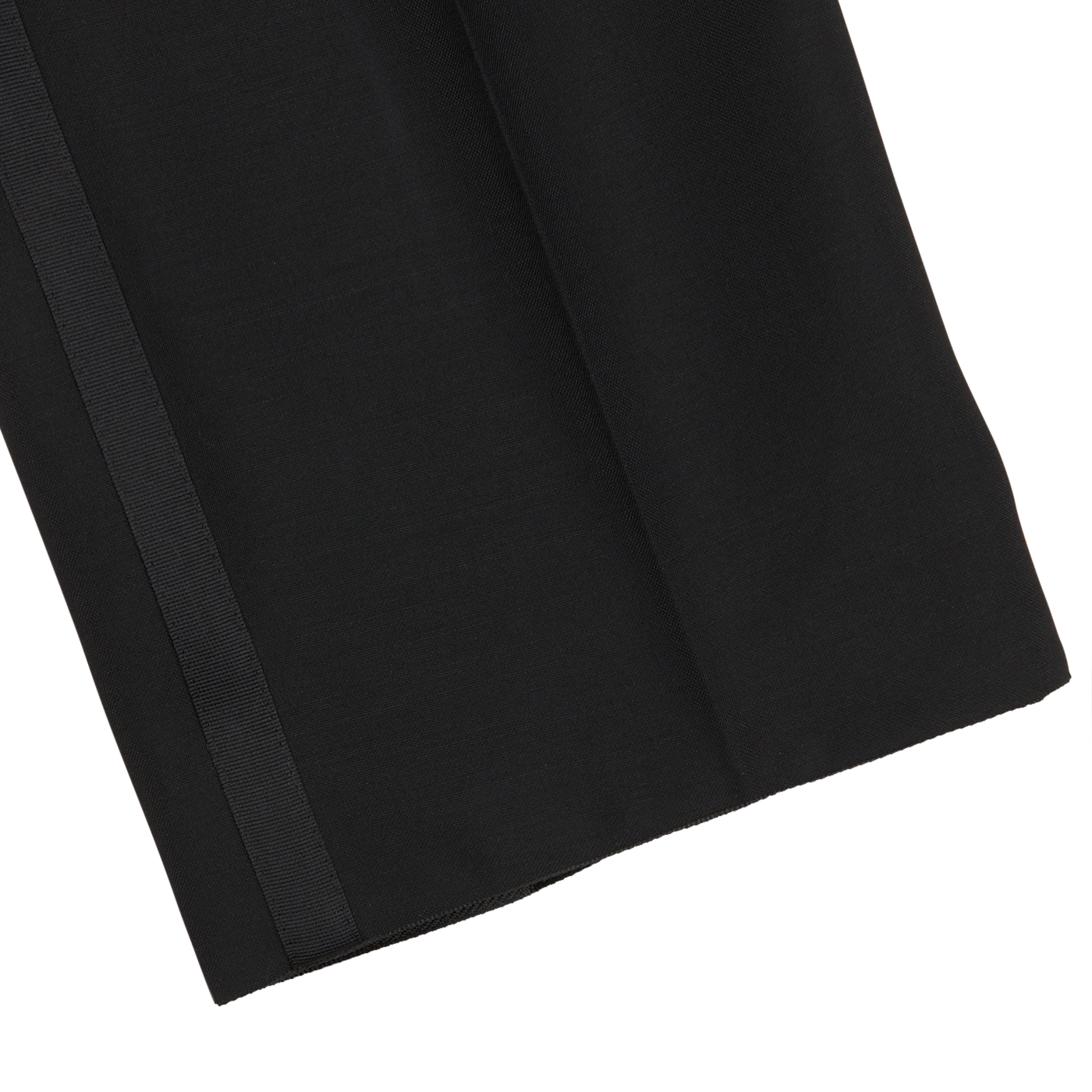 A close-up of a black wool-mohair blend fabric with a subtle vertical stripe on the left side and a white background partially visible at the bottom corner, evoking the formal look of Baltzar Sartorial Black Wool Mohair Tuxedo Pleated Trousers.