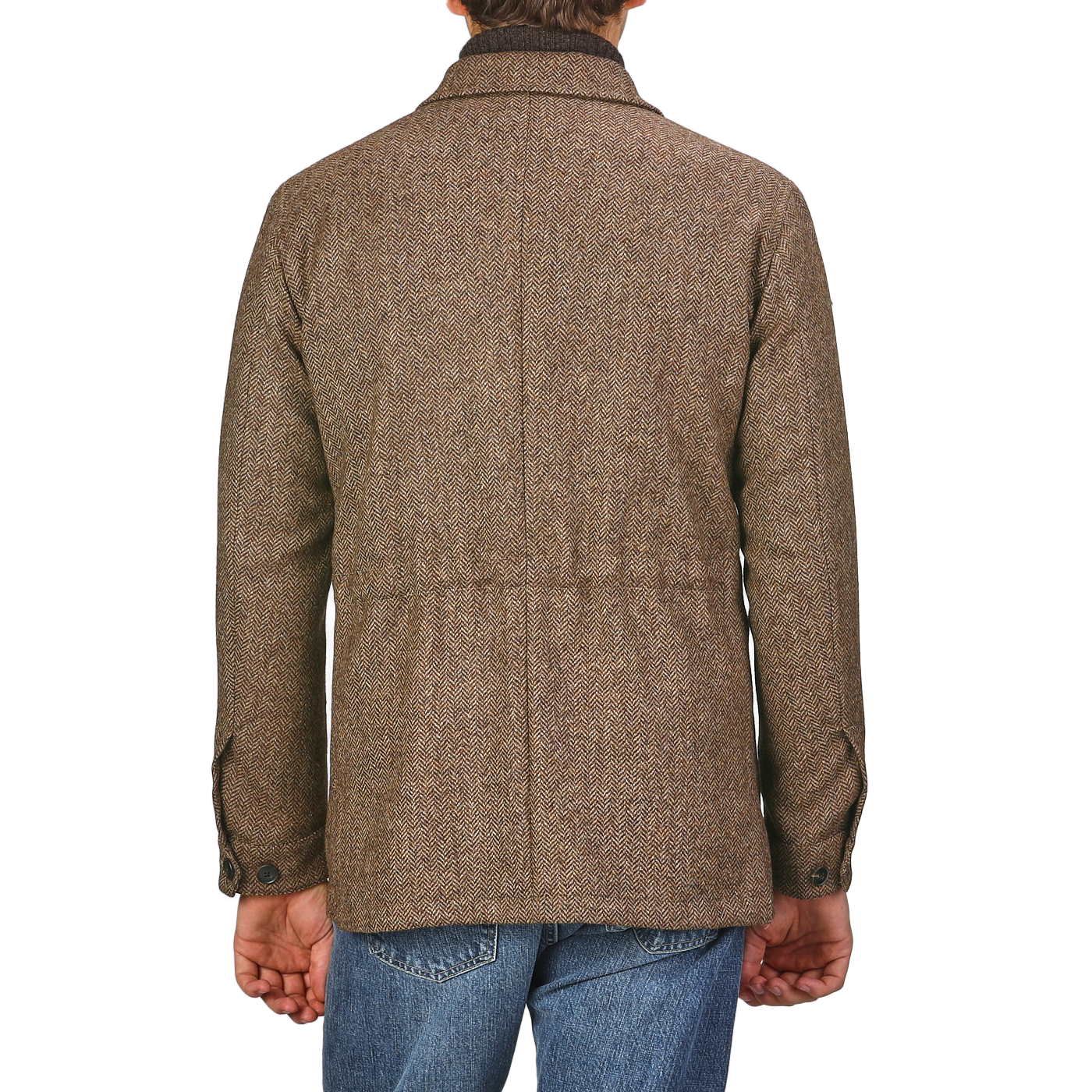 Back view of a person wearing a Brown Herringbone Wool Tweed Utility Jacket by Baltzar Sartorial and blue jeans, standing against a plain background.