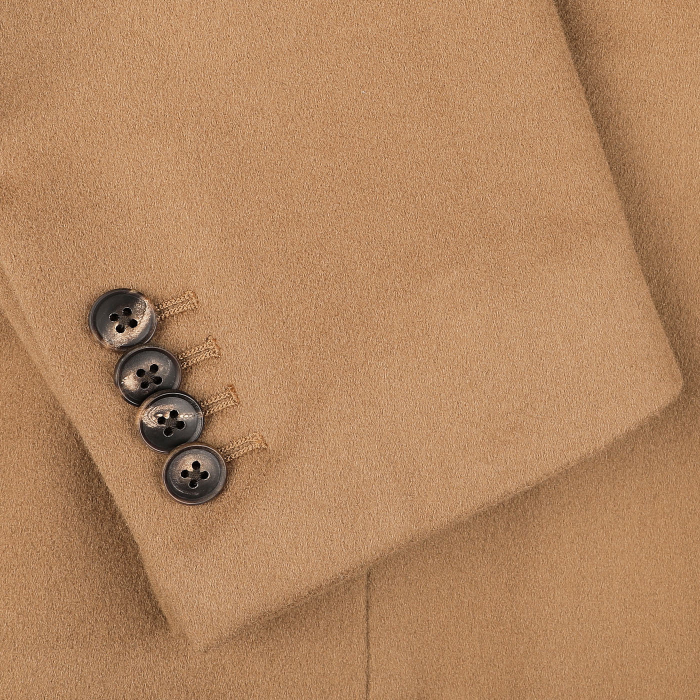 Close-up of a sleeve from the Camel Beige Loro Piana Wool Tailored Coat by Baltzar Sartorial, featuring four dark buttons in a row and crafted from pure wool.