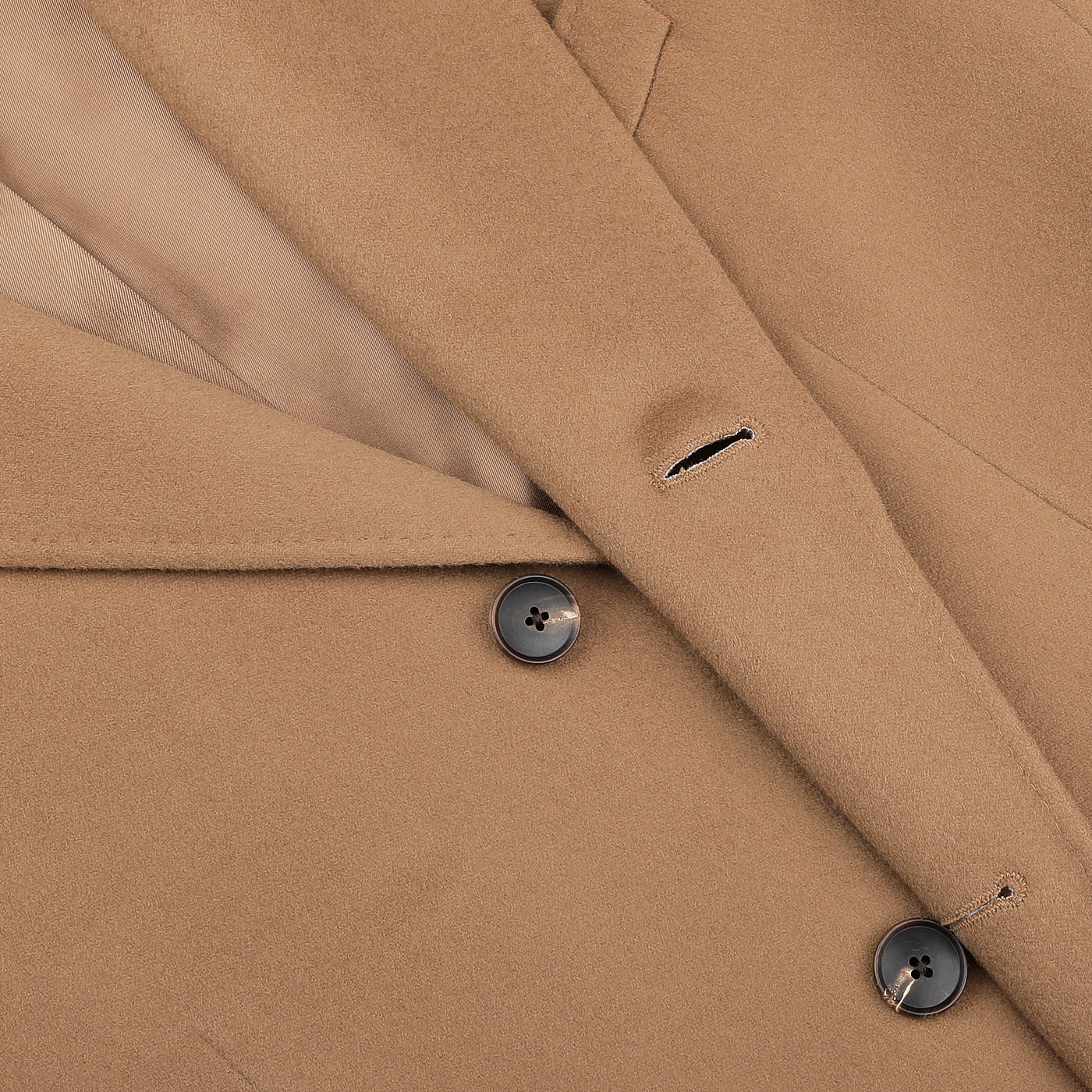 Close-up of the Baltzar Sartorial Camel Beige Loro Piana Wool Tailored Coat, highlighting its black buttons and detailed lapel and buttonholes.