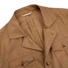 The Brown textured button-up shirt with two chest pockets and a flat collar is laid flat on a white surface, offering a stylish alternative to the tailored Camel Brown Wool Silk Linen Safari Jacket by Baltzar Sartorial.