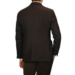 A person wearing a Baltzar Sartorial Dark Brown Wool Tweed Blazer and brown corduroy pants, viewed from the back against a plain background.