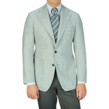 A man wearing a Baltzar Sartorial Green Houndstooth Wool Silk Linen Blazer made with a wool-silk-linen blend fabric.