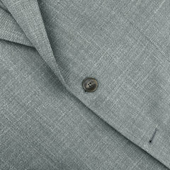 Close-up of the Baltzar Sartorial Green Wool Silk Linen Hopsack Blazer, showcasing its textured finish with a single button and neat stitching for a luxurious touch.