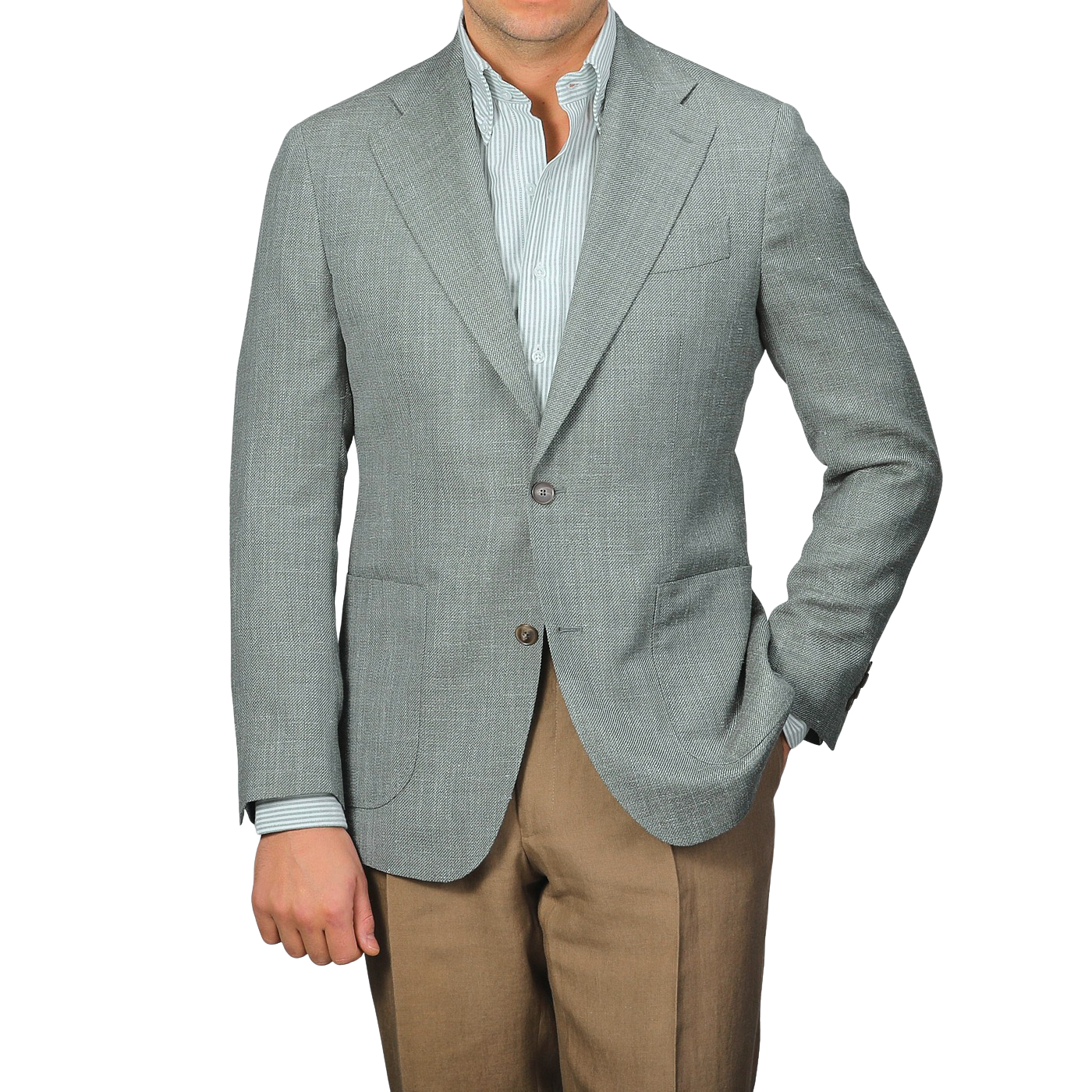 A man wearing a green wool silk linen hopsack blazer from Baltzar Sartorial over a striped shirt with brown pants, standing with one hand in his pocket.