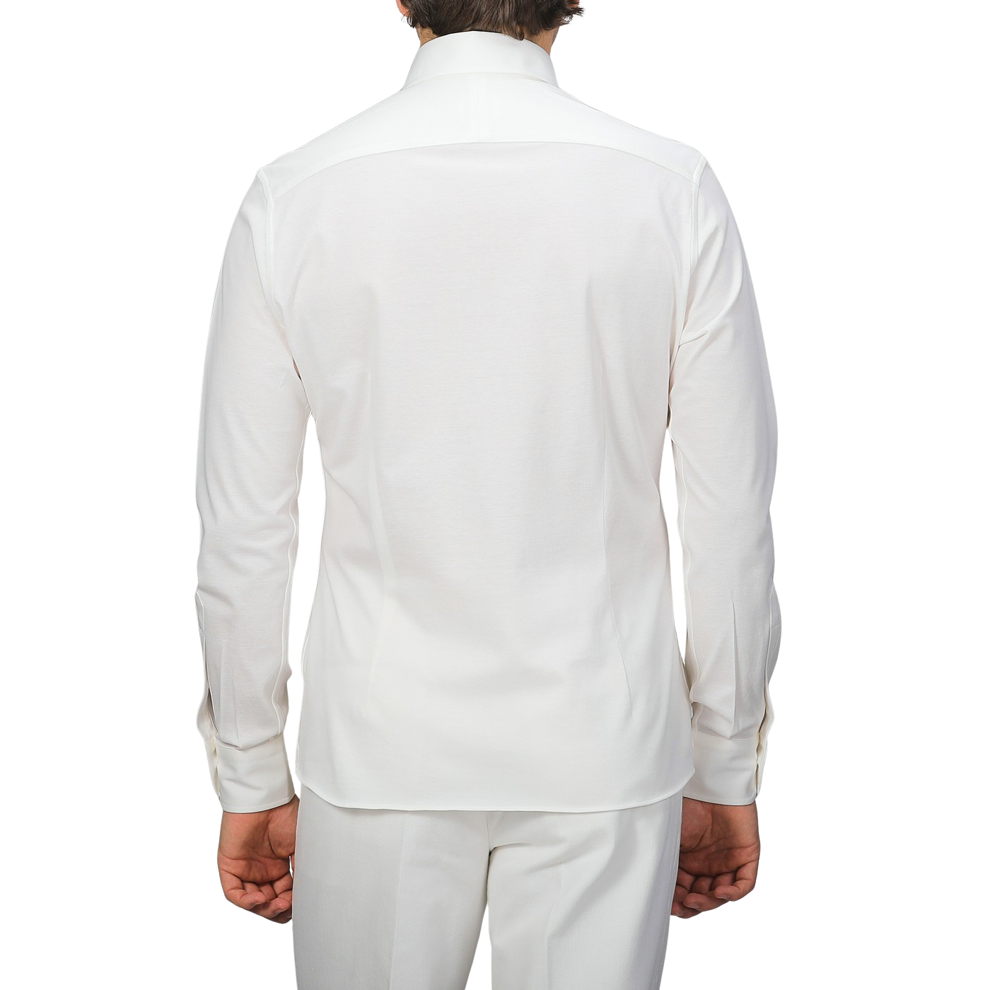 Rear view of a person wearing a Baltzar Sartorial Ivory White Cotton Piqué BD Popover Shirt and matching white pants against a plain background.