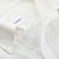 An Ivory White Cotton Piqué BD Popover Shirt, crafted from luxurious cotton piqué, features a button-down collar and a visible label reading "Baltzar Sartorial Made in Vietnam," highlighting its elegant craftsmanship.