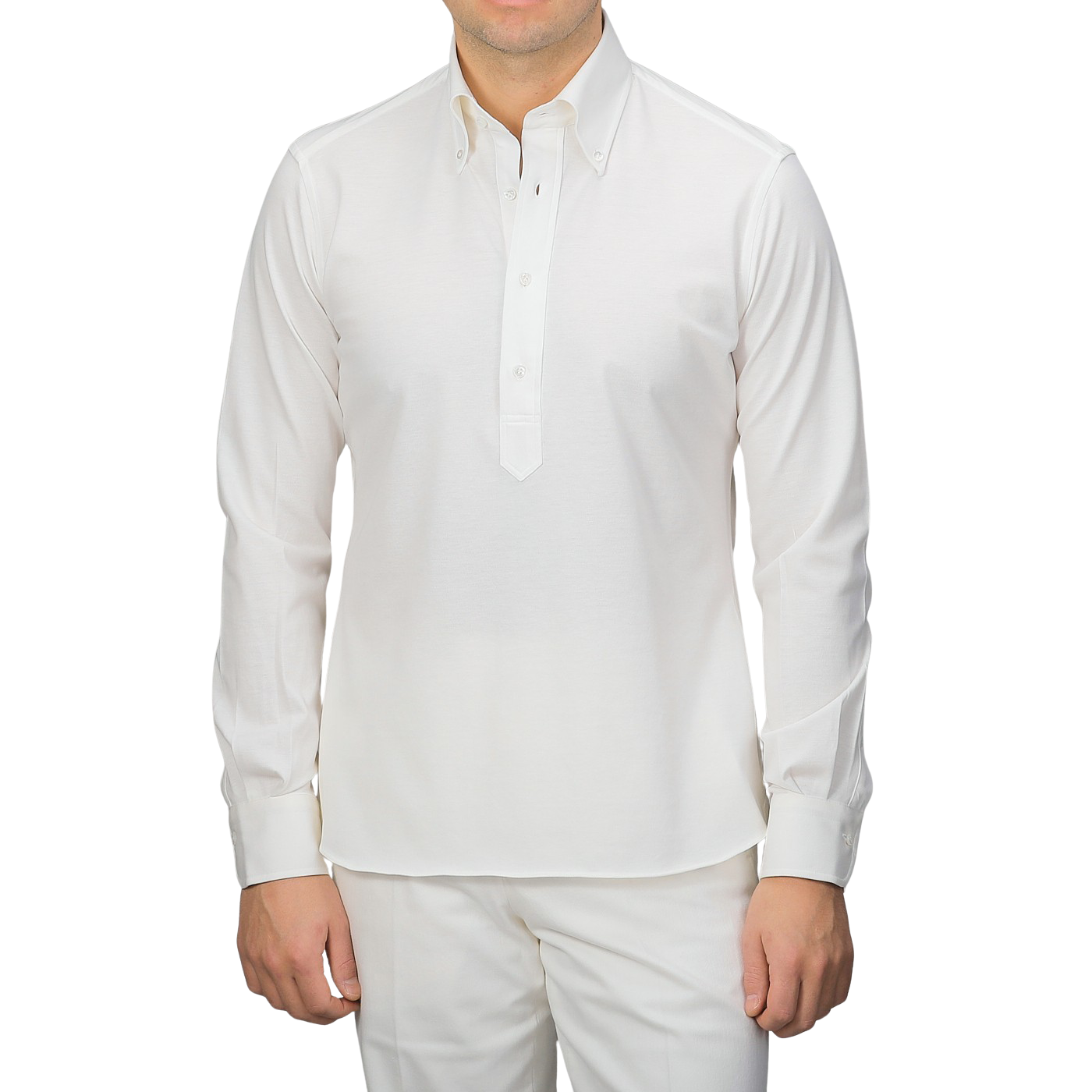 A person in an Ivory White Cotton Piqué BD Popover Shirt by Baltzar Sartorial and white pants, facing forward.