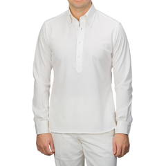 A person in an Ivory White Cotton Piqué BD Popover Shirt by Baltzar Sartorial and white pants, facing forward.