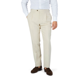 A man in a white shirt and Baltzar Sartorial Light Beige Pure Linen Pleated Trousers.