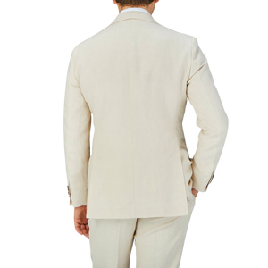 The back view of a man wearing a Baltzar Sartorial Light Beige Pure Linen Suit Jacket and linen fabric trousers.