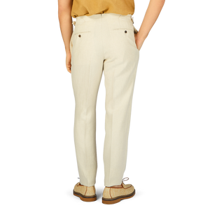 The back view of a woman in Baltzar Sartorial's Light Beige Pure Linen Flat Front Trousers and a tan shirt with a tailored fit.