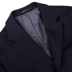 Flat lay of the Baltzar Sartorial Navy Blue Loro Piana Wool Tailored Coat, highlighting its notched lapel collar and visible gray lining against a white background.