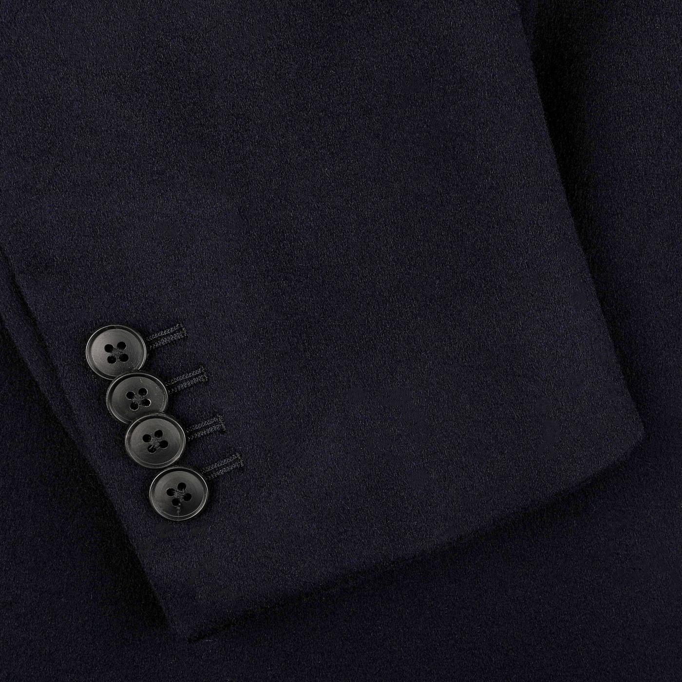 Close-up of the sleeve of the Navy Blue Loro Piana Wool Tailored Coat by Baltzar Sartorial, crafted from pure wool and featuring four black buttons on the cuff.