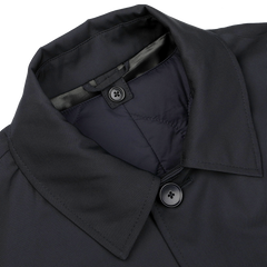 A close-up of a navy blue car coat from Baltzar Sartorial, featuring a collar, the top two buttons, and quilted Thermore Ecodown lining.