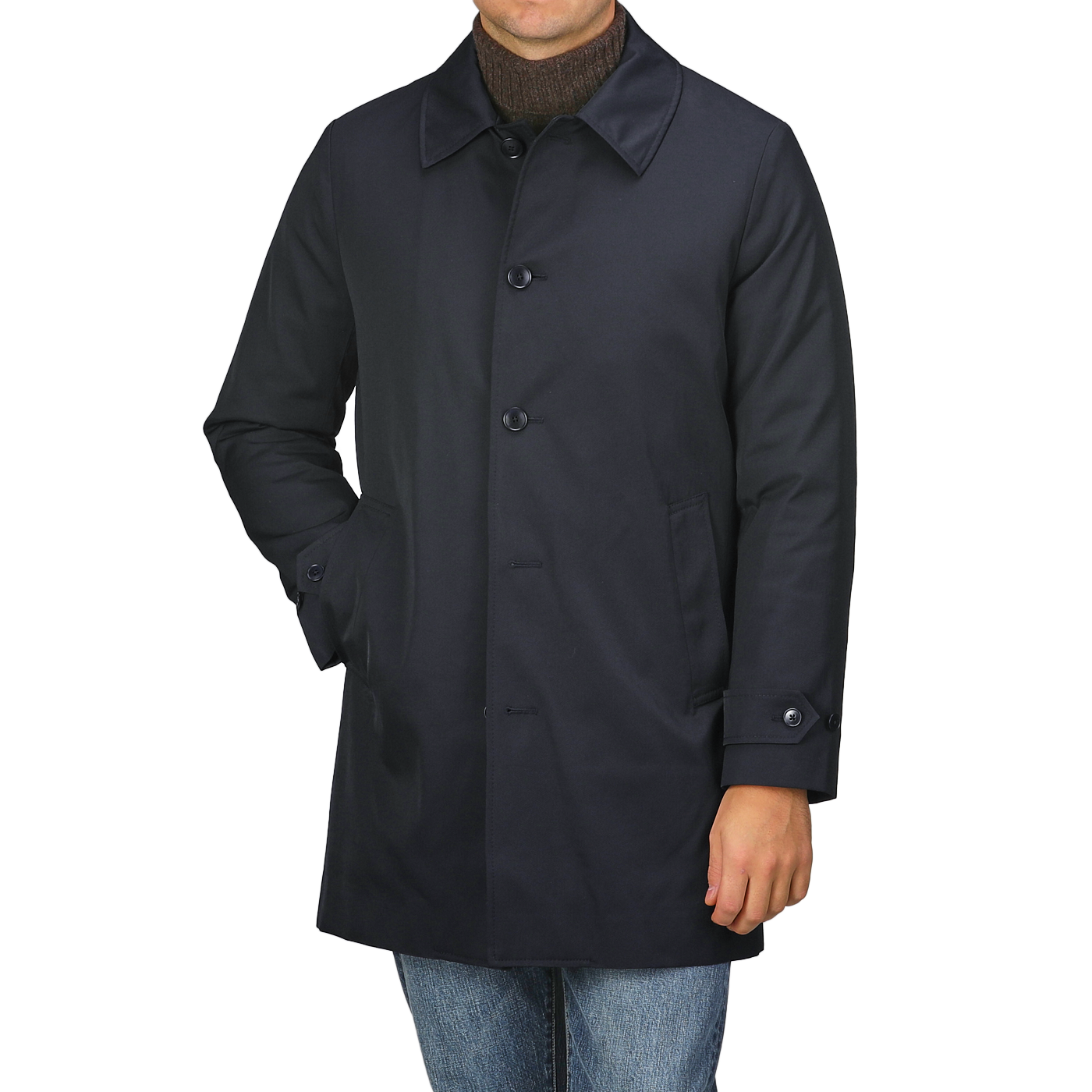 A person is standing against a plain background wearing the Navy Blue Nylon Thermore Padded Car Coat by Baltzar Sartorial, featuring button closure and Thermore Ecodown lining, paired with jeans.