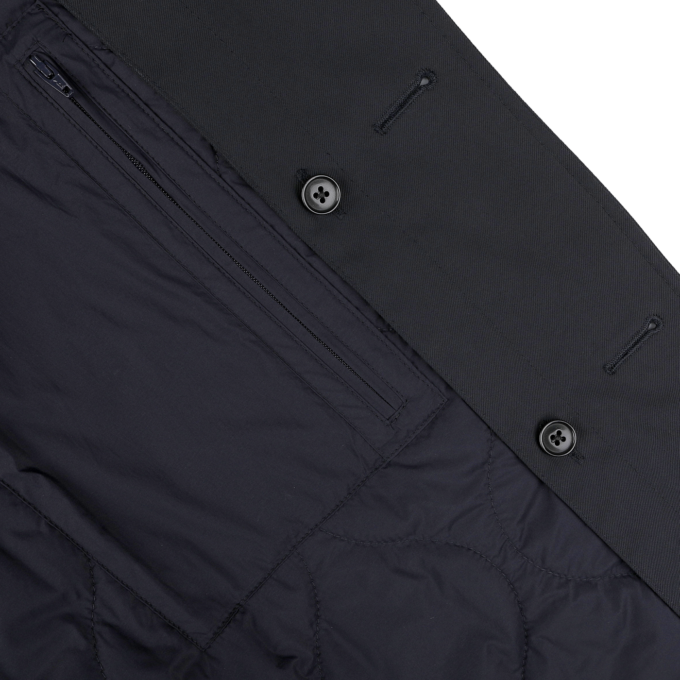 Close-up of the interior of Baltzar Sartorial's Navy Blue Nylon Thermore Padded Car Coat, featuring a zippered pocket, button details, quilted stitching, and Thermore Ecodown lining.