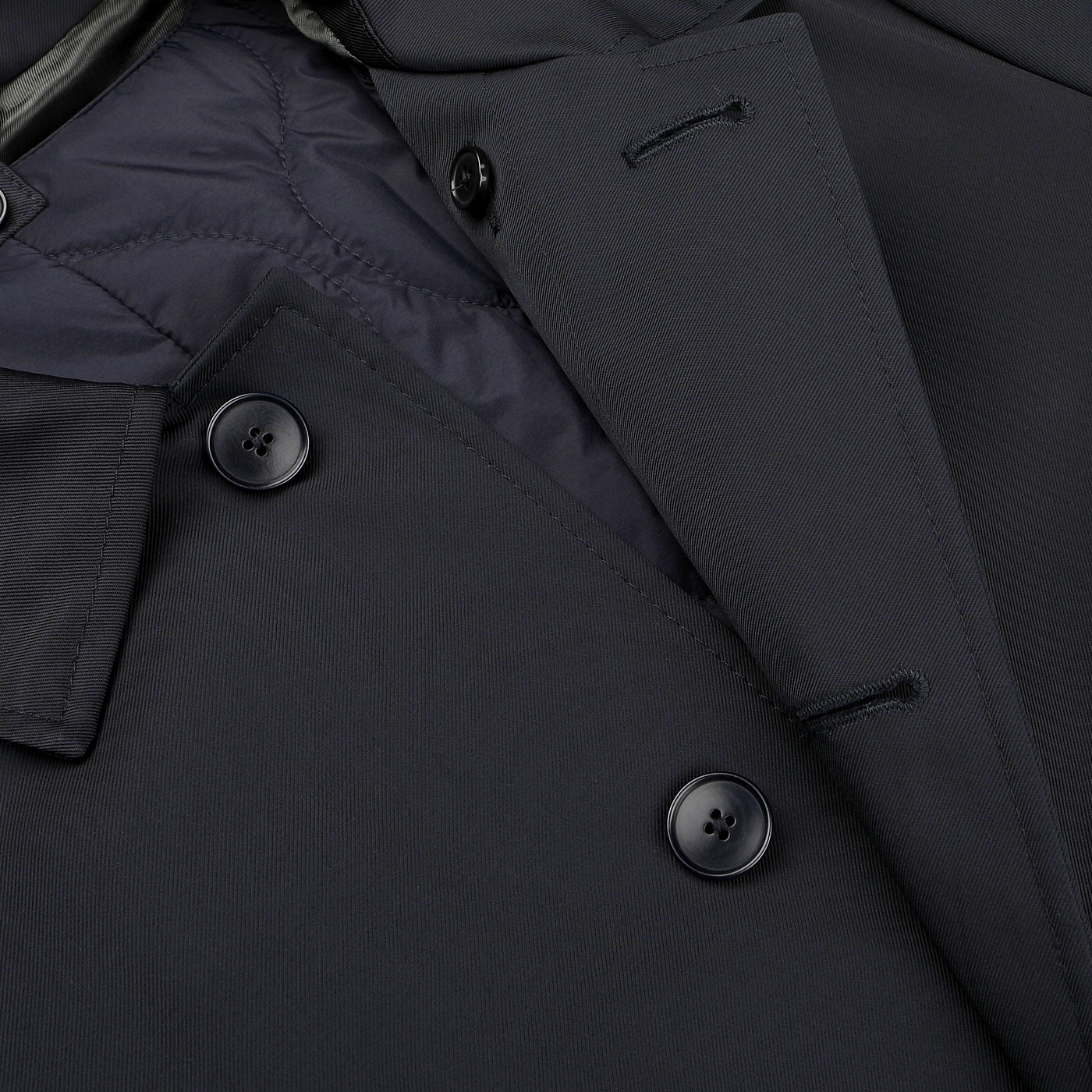 Close-up of the Baltzar Sartorial Navy Blue Nylon Thermore Padded Car Coat, showcasing its dark double-breasted design with four buttons and a quilted Thermore Ecodown lining for enhanced warmth.