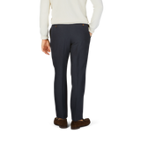 The back view of a man wearing Baltzar Sartorial navy blue pure linen pleated trousers and a white sweater.