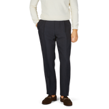 A man in a white sweater and Baltzar Sartorial Navy Blue Pure Linen Pleated Trousers.