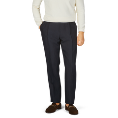 A man in a white sweater and Baltzar Sartorial Navy Blue Pure Linen Pleated Trousers.