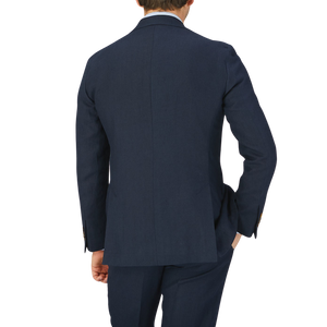 The back view of a man wearing a Baltzar Sartorial Navy Blue Pure Linen Suit Jacket and tailored trousers.