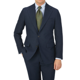 A man in a tailored Baltzar Sartorial Navy Blue Pure Linen Suit Jacket posing for a photo, wearing linen fabric trousers.