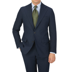 A man in a tailored Baltzar Sartorial Navy Blue Pure Linen Suit Jacket posing for a photo, wearing linen fabric trousers.