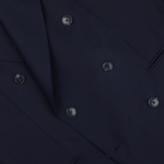 Close-up of a Baltzar Sartorial navy blue double-breasted suit jacket made from super 100’s wool fabric, showing detailed stitching and buttons.