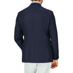 A man wearing a Baltzar Sartorial navy blue wool hopsack blazer and white trousers viewed from the back.