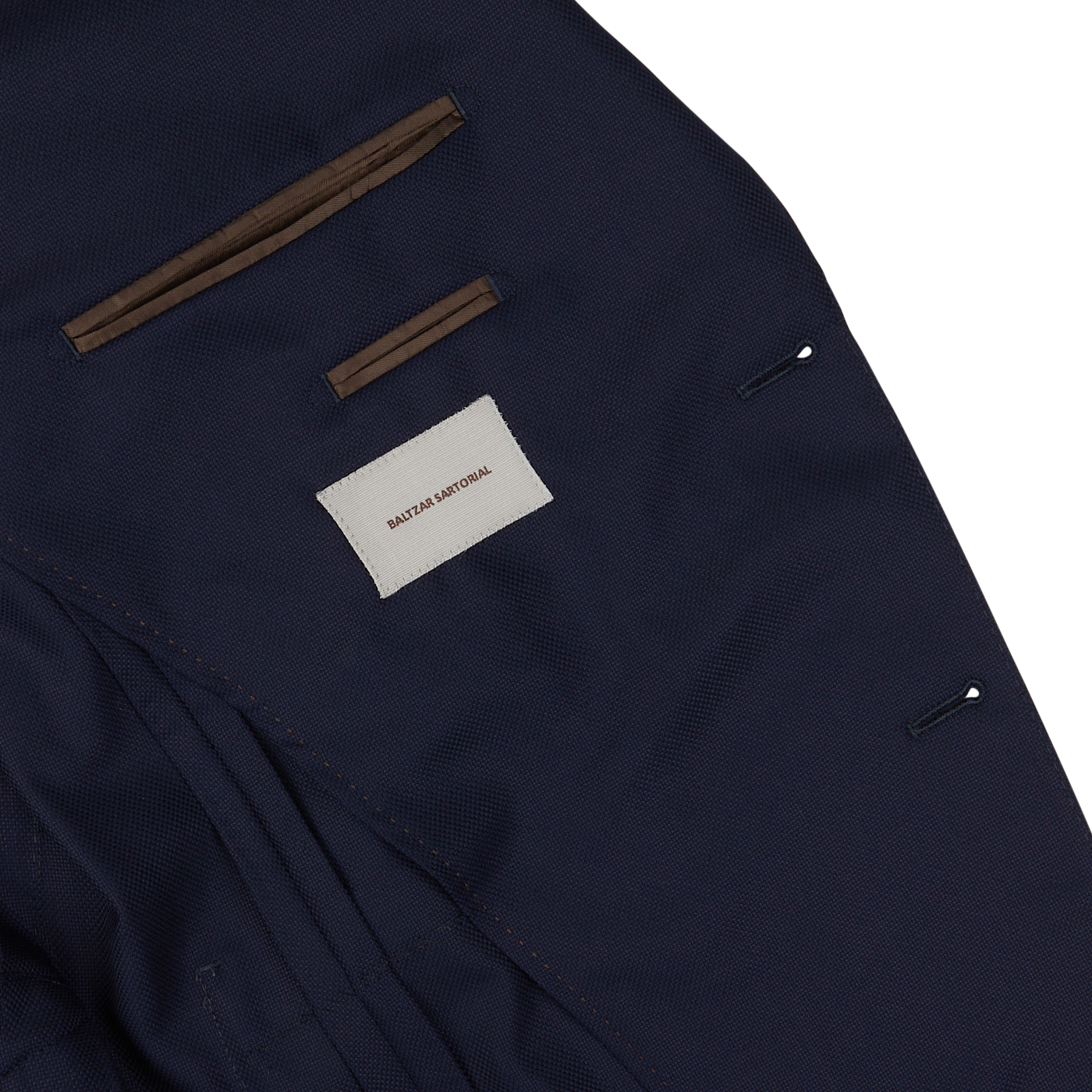 Close-up of a Baltzar Sartorial navy hopsack blazer label and stitching details.