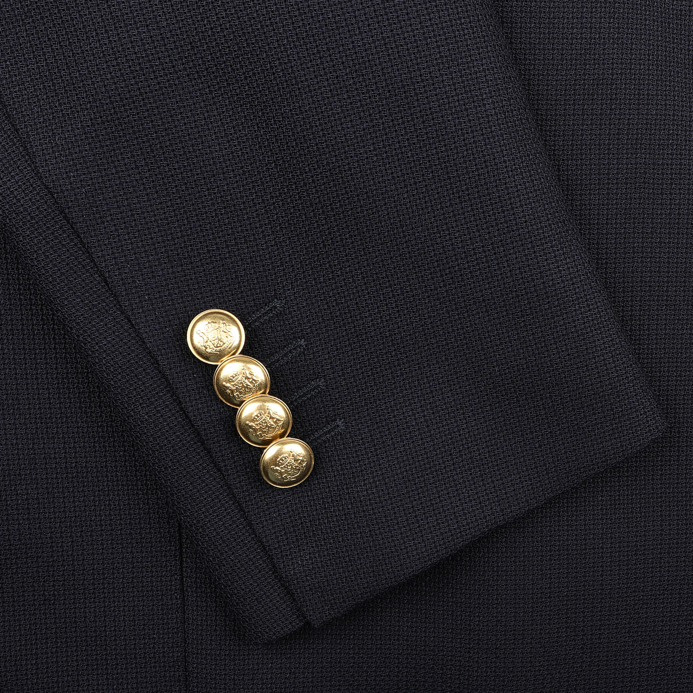 The sleeve close-up of the Baltzar Sartorial Navy Blue Wool Mock Leno DB Club Blazer highlights four gold buttons and its pure wool craftsmanship.