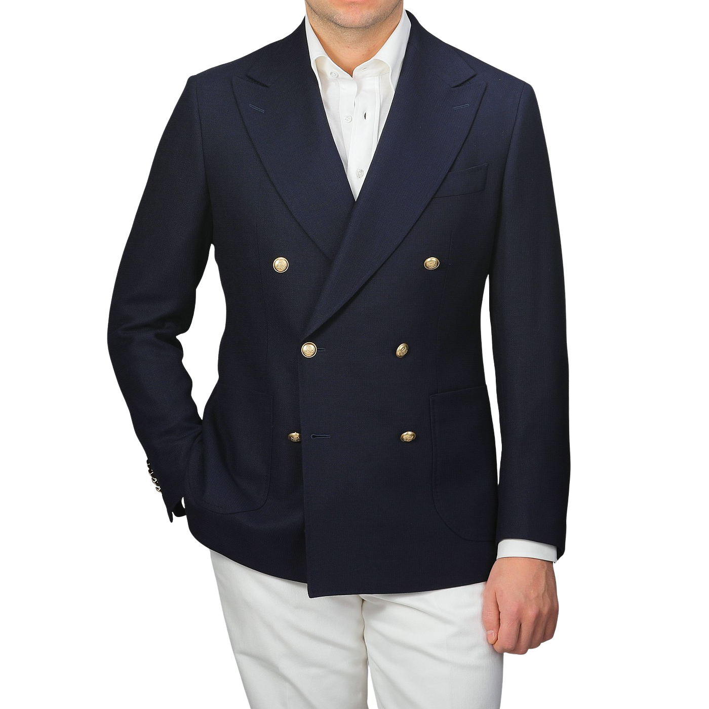 Wearing a Navy Blue Wool Mock Leno DB Club Blazer by Baltzar Sartorial with gold buttons, paired with a white shirt and white pants, exudes refined elegance.