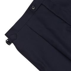 Close-up of a Baltzar Sartorial navy blue pleated skirt with a side button and a small buckle detail, crafted from super 100’s wool.