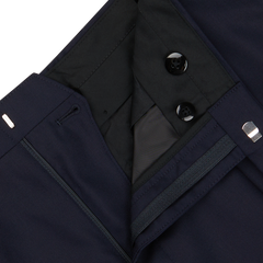 Close-up of a Navy Super 100's Wool Pleated Suit Trousers from Baltzar Sartorial with black buttons, a zipper, and visible inner lining.