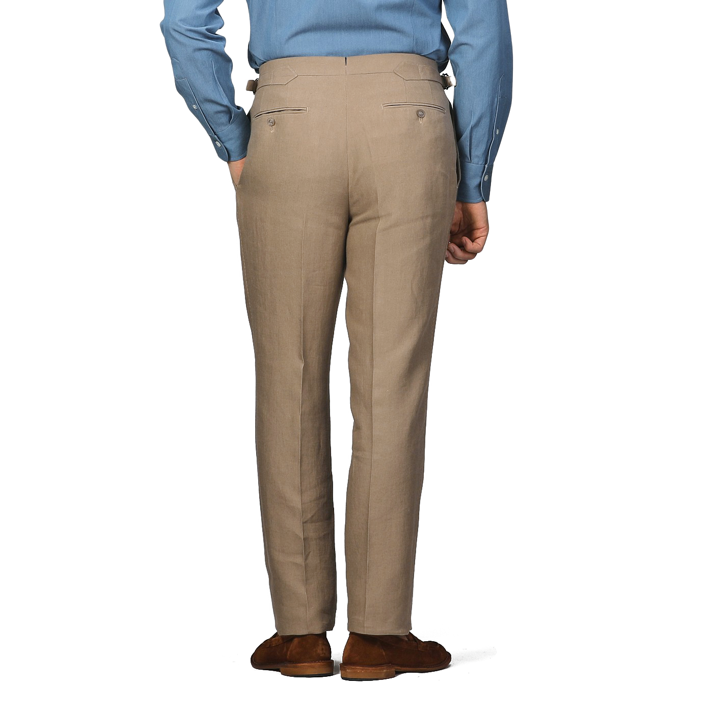 A man in a blue shirt and Taupe Beige Pure Linen Pleated Trousers from Baltzar Sartorial stands with his hands at his sides, viewed from behind.